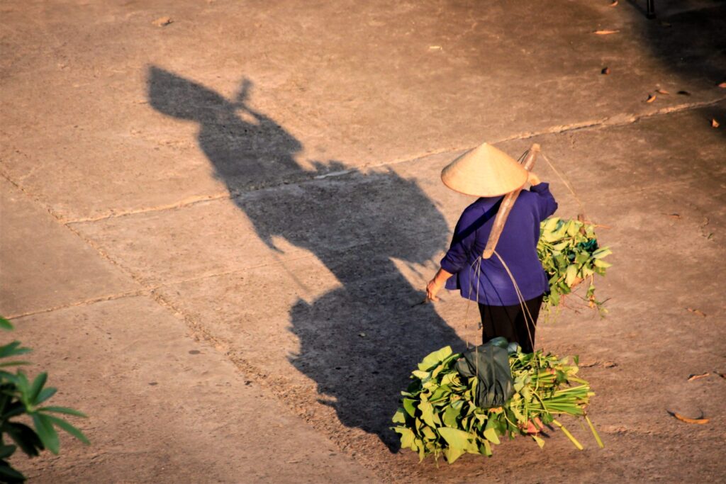 Where To Stay In Hanoi | Your One-stop Neighborhood Guide 9 A woman carrying her don ganh in Ha Noi. Photo by VIA Ambassador Florian Commans - Where To Stay In Hanoi | Your One-stop Neighborhood Guide