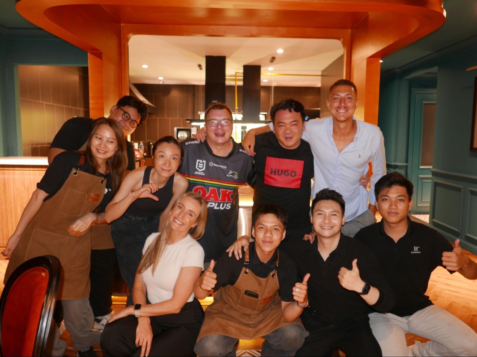 Group photo of author Lauren Tracy with Cesar Huelva Garcia, Chef Nghiem, and the El Toro team at a community dinner in Thao Dien.