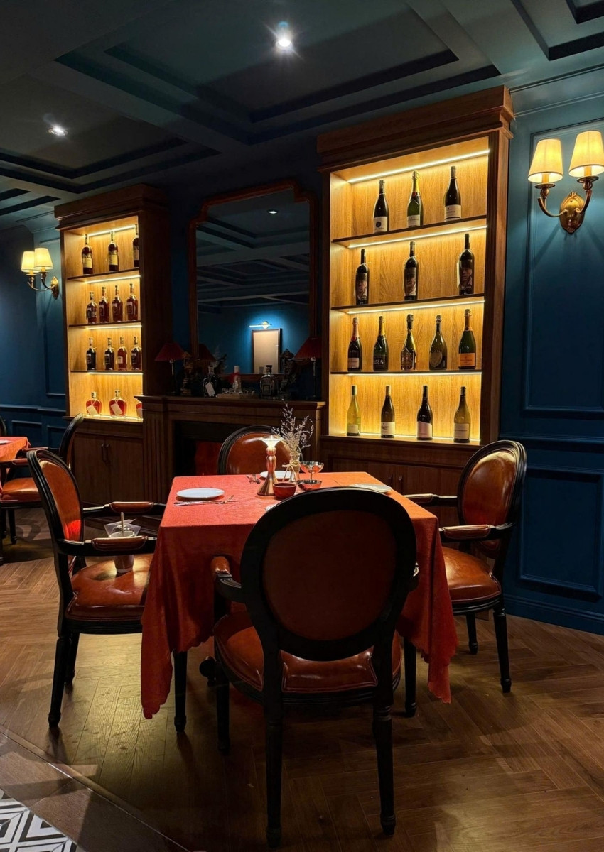 Intimate corner table at El Toro framed by softly lit wine shelves and classic wooden furniture.