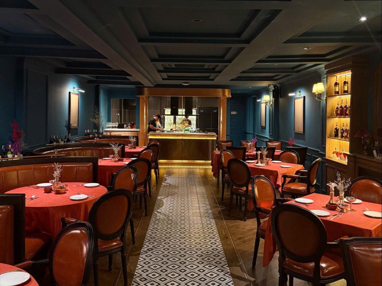 View of El Toro’s dining room with warm lighting and stylish round tables set for dinner.